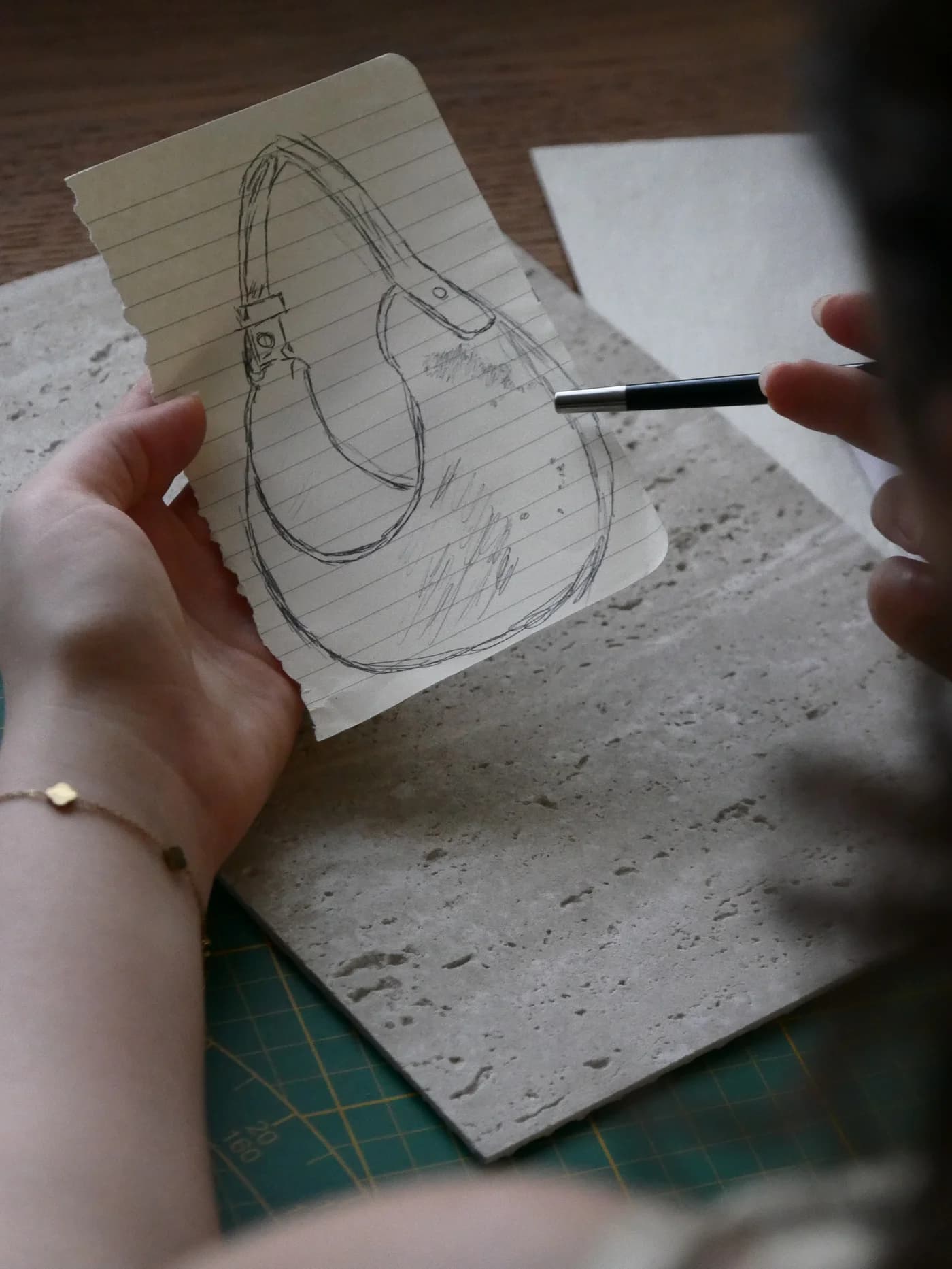 A drawing of PORTALE on paper, held above pale stone